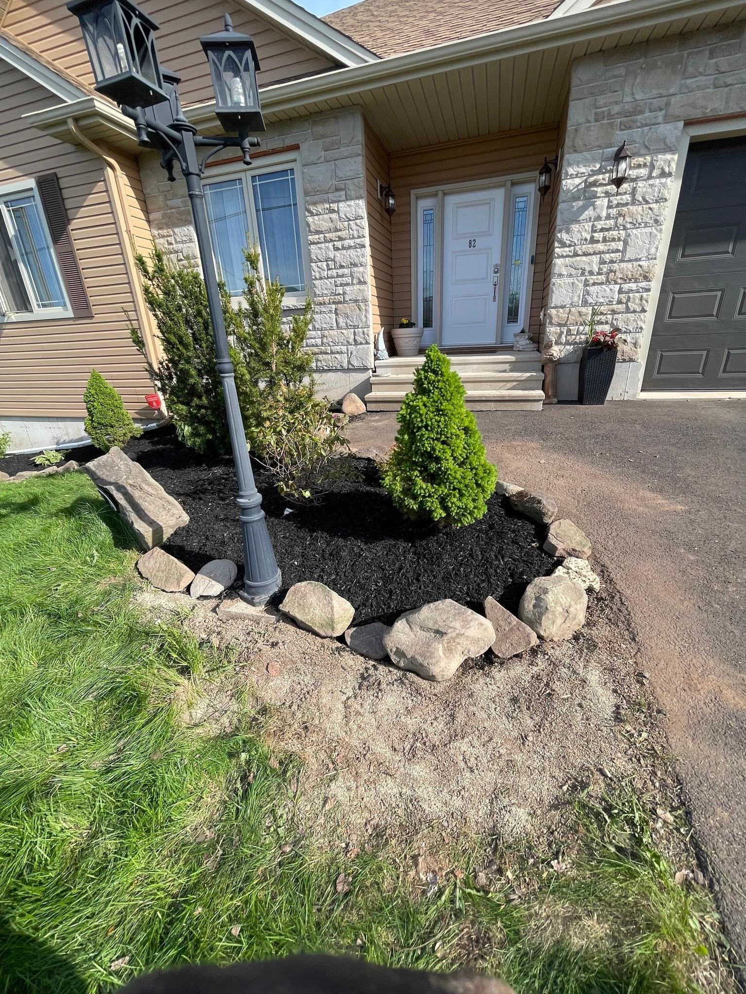 Fresh flower bed with mulch and shrubs at a home entrance